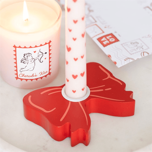 Red Bow Taper Candle Holder Valentines Day Decor Set with candle and decorative items.