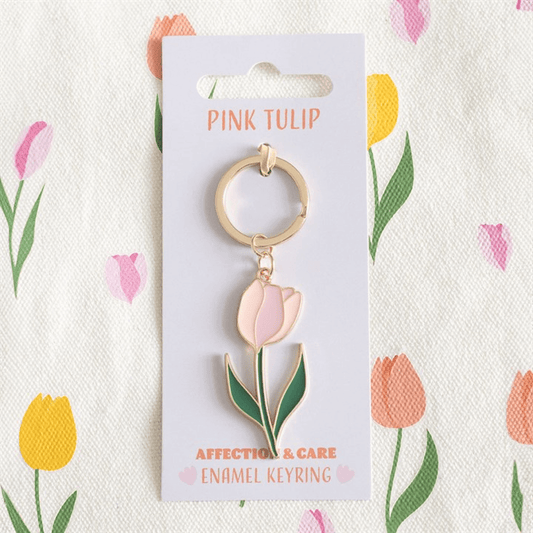 Pink Tulip Keyring on floral patterned background, featuring a charming pink tulip design with metal alloy and enamel.