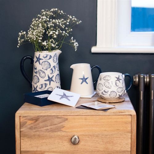 Stylishly showcase blooms in the 17cm Seashell Ceramic Flower Jug, adorned with charming blue seashells and starfish.