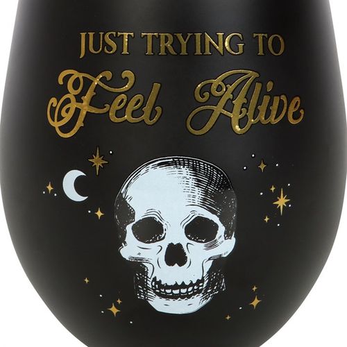 Trying to Feel Alive Stemless Wine Glass showcases a playful skeleton design in black and gold, perfect for celebrations.